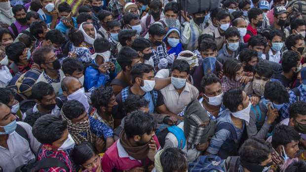 Indian migrant workers crowd to board buses to return to their native villages after a nationwide lockdown was announced.