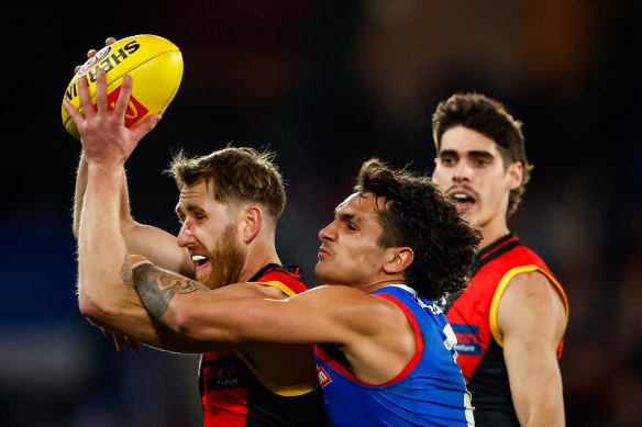 Dyson Heppell of the Bombers marks the ball ahead of Jamarra Ugle-Hagan of the Bulldogs.