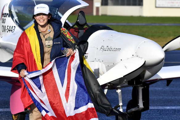 Belgium-British teenage pilot Zara Rutherford carries the Belgian and British flags after landing her Shark ultralight plane at the Kortrijk airport, Belgium.