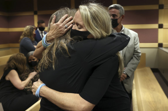 Family members of the shooting victims comfort each other following the court hearing.