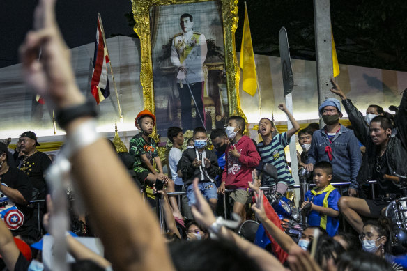 A painting of Thailand King Maha Vajiralongkorn is seen as protesters hold the three finger salute during a rally last week.