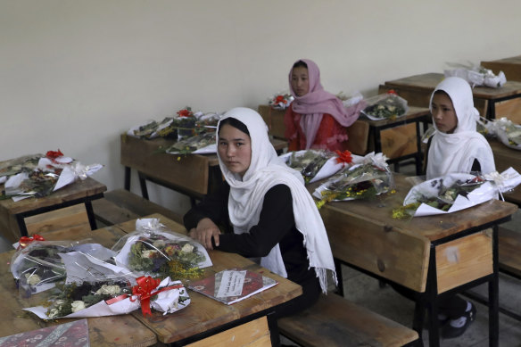 Schoolgirls sit inside a classroom with bouquets of flowers on empty desks in May as a tribute to those killed in the brutal bombing of the Syed al-Shuhada girls’ school on May 8.