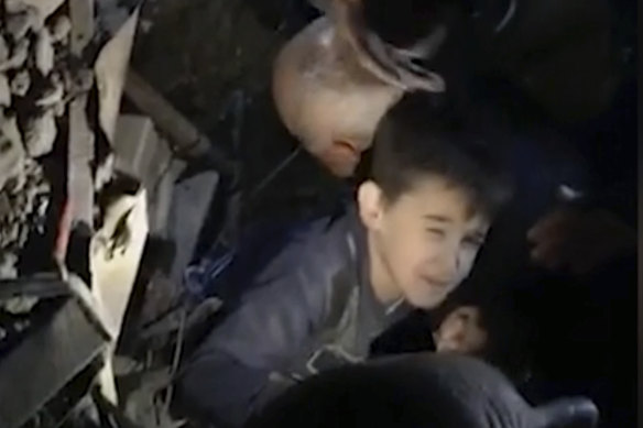 People work to free a young boy from a collapsed building in the coastal town of Durres.