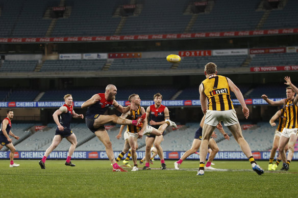 Max Gawn gets a kick away for the Demons in their draw with Hawthorn at a crowdless MCG.