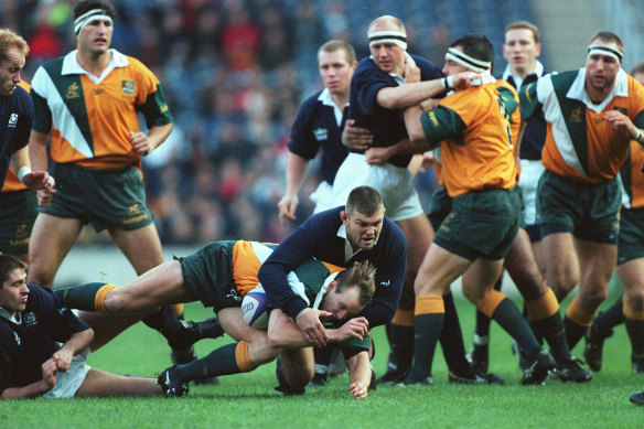 Brett Robinson playing for the Wallabies against Scotland on November 25, 1997, being tackled by Eric Peters.