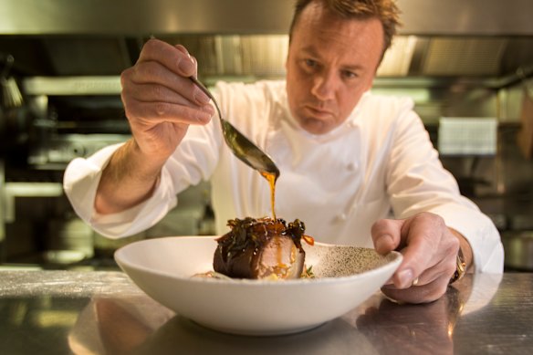 Teage Ezard plating one of his best known dishes, pork hock with chilli caramel, at Ezard Restaurant in 2014. 
