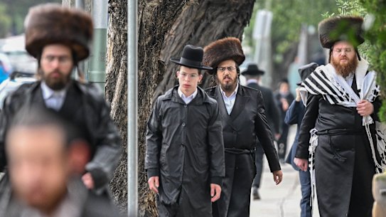 Members of the Adass Israel congregation walk to their temporary synagogue for services on Saturday, December 7.