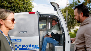Philip Langsdorf is placed inside a police van.