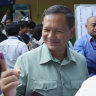 Hun Manet, of the Cambodian People’s Party, son of Cambodia Prime Minister Hun Sen, also army chief, shows off his inked finger outside a polling station after voting in Phnom Penh, Cambodia.