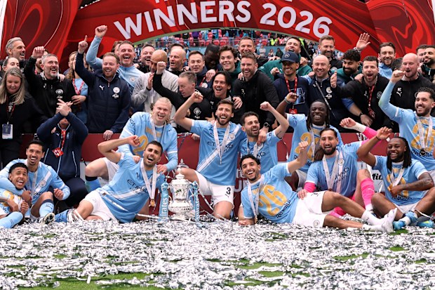 Manchester City players pose with the winner's trophy after the English FA Cup final soccer match between Chelsea and Manchester City in London, Saturday, May 16, 2026. (AP Photo/Richard Pelham)