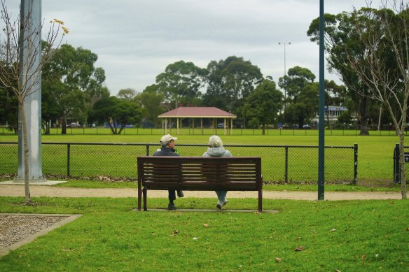 Two parkgoers relax on a bench at Centenary Park, Bentleigh East. 