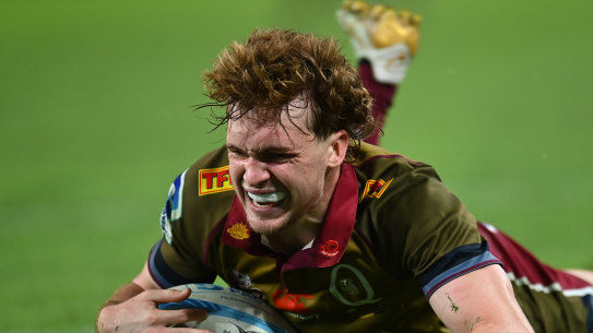 Tim Ryan of the Reds scores a try against the Blues.
