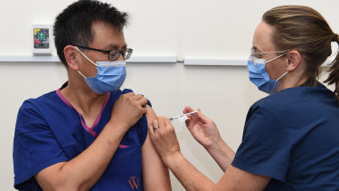 Professor Allen Cheng, left, co-chair of the federal government’s immunisation advisory body, received the Pfizer vaccine at The Alfred hospital in March.