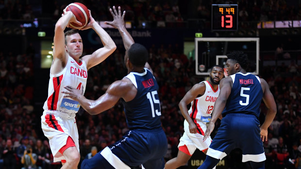 Brady Heslip of Canada under pressure from Kemba Walker of the USA.