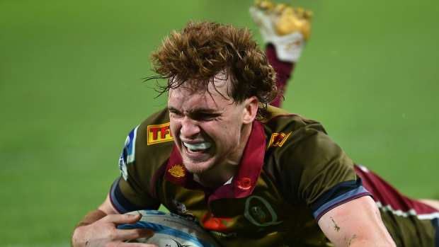 Tim Ryan of the Reds scores a try against the Blues.