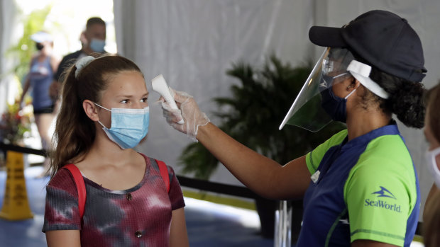A woman has her temperature checked before entering SeaWorld in Orlando, Florida. The theme park reopened on June 11.