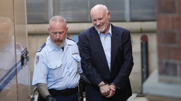 Former minister Ian Macdonald is taken into custody following a court hearing in May 2017.