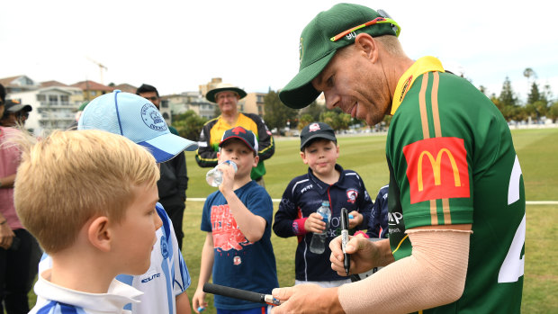David Warner signs autographs at Coogee Oval on Saturday afternoon. 
