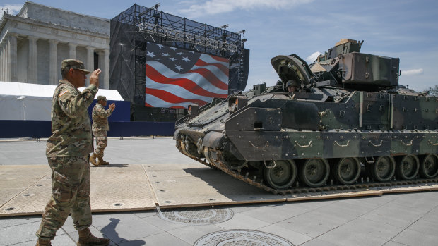 Army soldiers with the 3rd Infantry Division, 1st Battalion, 64th Armored Regiment, move a Bradley Fighting Vehicle into place by the Lincoln Memorial.