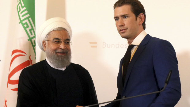 Hassan Rouhani shakes hand with Austrian Chancellor Sebastian Kurz at the federal chancellery in Vienna.