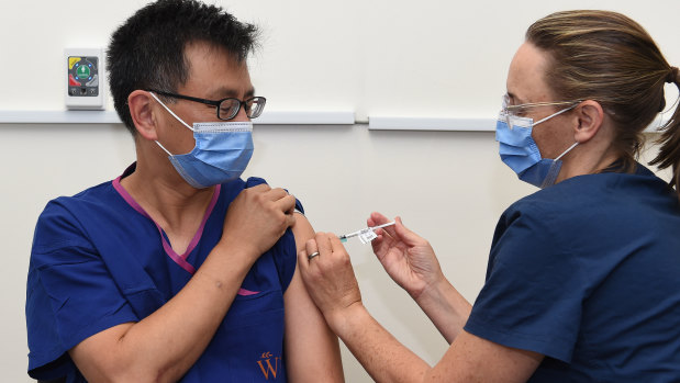 Professor Allen Cheng, left, co-chair of the federal government’s immunisation advisory body, received the Pfizer vaccine at The Alfred hospital in March.