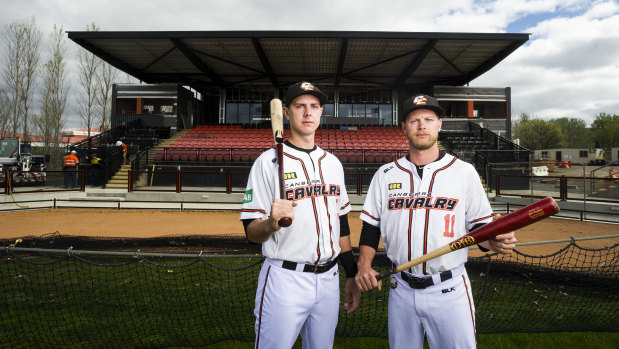The Cavalry's Perkins brothers, Robbie and Kyle, in front of the soon-to-be-finished grandstand, which will help lure international baseball to Canberra.