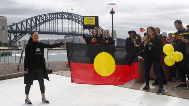 Cheree Toka and fellow demonstrators hold an Aboriginal Flag during a demonstration in Sydney.