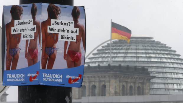 A poster of the far-right Alternative for Germany reads "Burqa? We prefer bikinis" near the Reichstag building in Berlin.