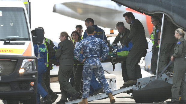 A survivor of the Whaakaari volcanic eruption in New Zealand is removed on a stretcher from a RAAF Hercules at Sydney Airport on Thursday.