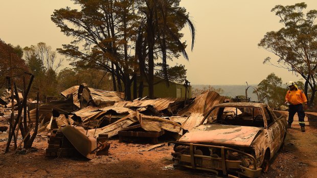 RFS assessment officer Adam Small inspects a home burnt out during the Green Wattle Creek fire south-west of Sydney.