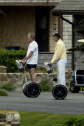 Then US President George W. Bush (left) and his father former President George Bush ride Segways in the front driveway of the Bush family summer home in 2003.  