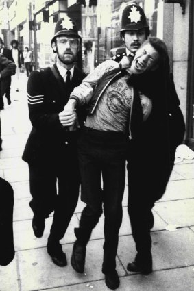 Collared ... A youth is marched away by police at the height of the rioting.