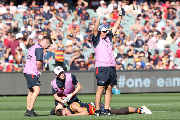 Jake Kelly of the Crows lays on the ground concussed after a clash with Patrick Dangerfield.