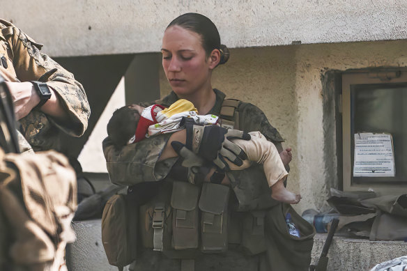 In this August 20, 2021, image, Sgt Nicole Gee calms an infant during the evacuation at Hamid Karzai International Airport in Kabul. Gee was later killed in a bombing outside the airport.