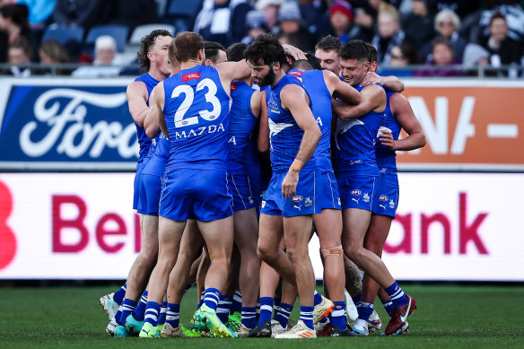 North Melbourne players celebrate with debutant Cooper Harvey.