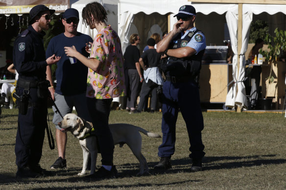 A police sniffer dog squad speak to a festival goer at Splendour on Saturday.