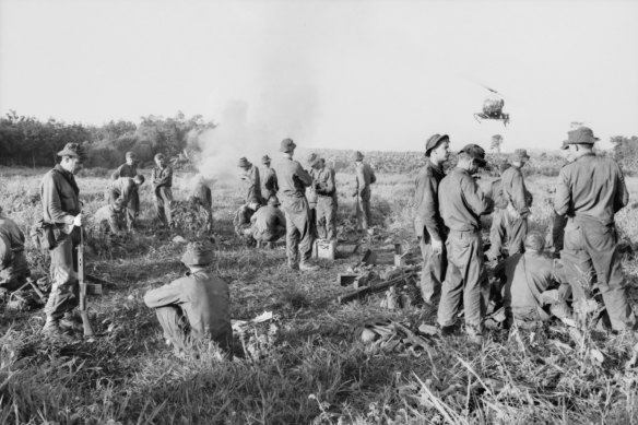 Weary Delta Company members having a hasty rations meal before returning to the battle area.