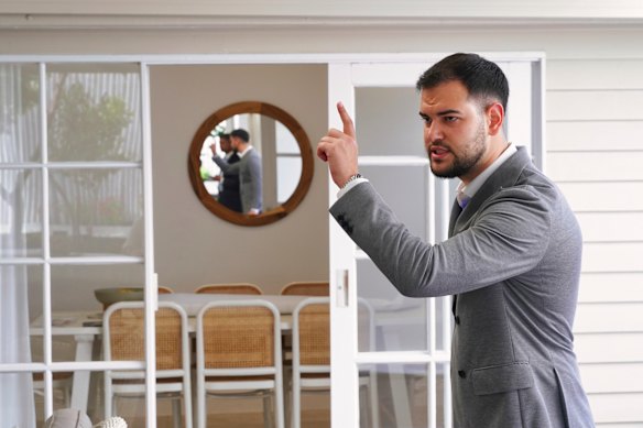 Ray White auctioneer Raphael Calik-Houston calls an auction undercover at the rear of 139 Nicholson Street.