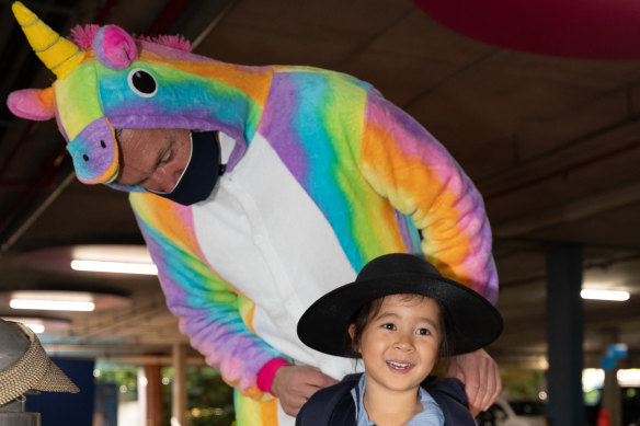 Mr Sandral - dressed as a unicorn - fixes Maddy Wong’s bag before she rushes into school.