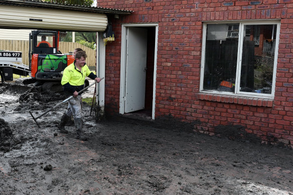 People clean up a flood damaged property near the Maribyrnong River.