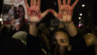 A protester “Time is running out” painted on her hands in Hebrew calls for a hostage deal in Jerusalem.