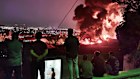 People observe fire and smoke from an Israeli attack on the Shahran oil depot in Tehran.