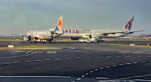 A Jetstar plane and a Qatar Airways plane on the runway at Sydney Airport on Sunday morning.