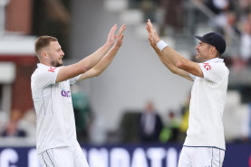 Newcomer Gus Atkinson (left) takes a West Indian wicket and the congratulations of his outgoing teammate James Anderson (right).