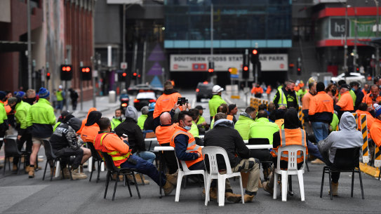 Construction workers outside a Lonsdale Street building site on Friday.