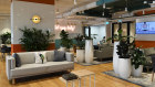The neon sign behind the desk reads "just enjoy today" at JustCo's Pitt Street hub.
