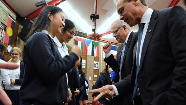 Prime Minister Scott Morrison and Federal Minister for Health Greg Hunt playing rock, paper scissors with students from Burwood Girls High School.