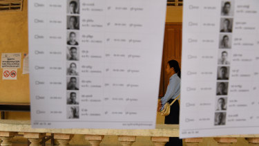 An election official stands among the voter lists at a polling station.