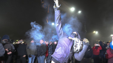 A protester throws a smoke grenade during a rally in front of the embassy of Russia in Kiev, Ukraine, on Sunday.