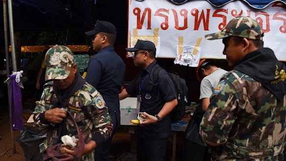 Thai rescuers collect food at the base camp at Tham Luang Cave.
